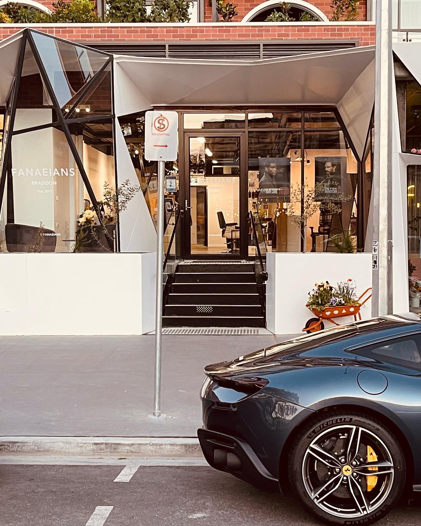 A luxury car parked outside the FANAEIANS Braddon salon
